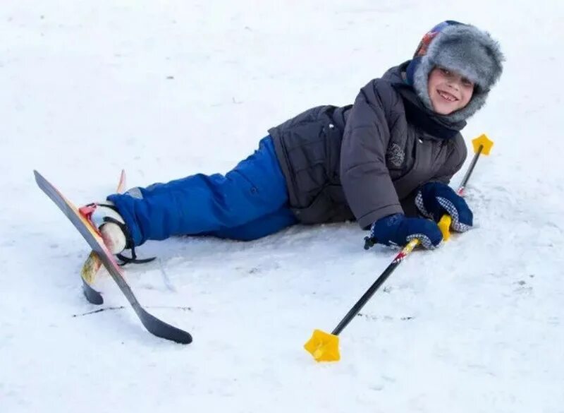 Мальчик катается на лыжах. Мальчик лыжник. Падение на лыжах. Лыжник упал.