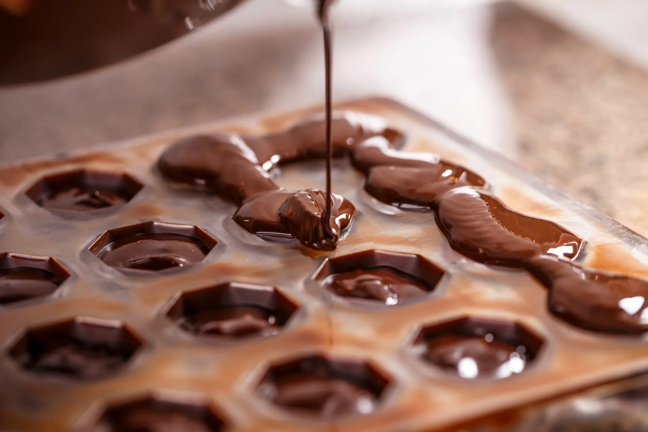 В шоколаде есть масла. Разлить шоколад по формам. Разливка шоколада в формы. Шоколад заливают в форму. Заливание шоколада в форму.