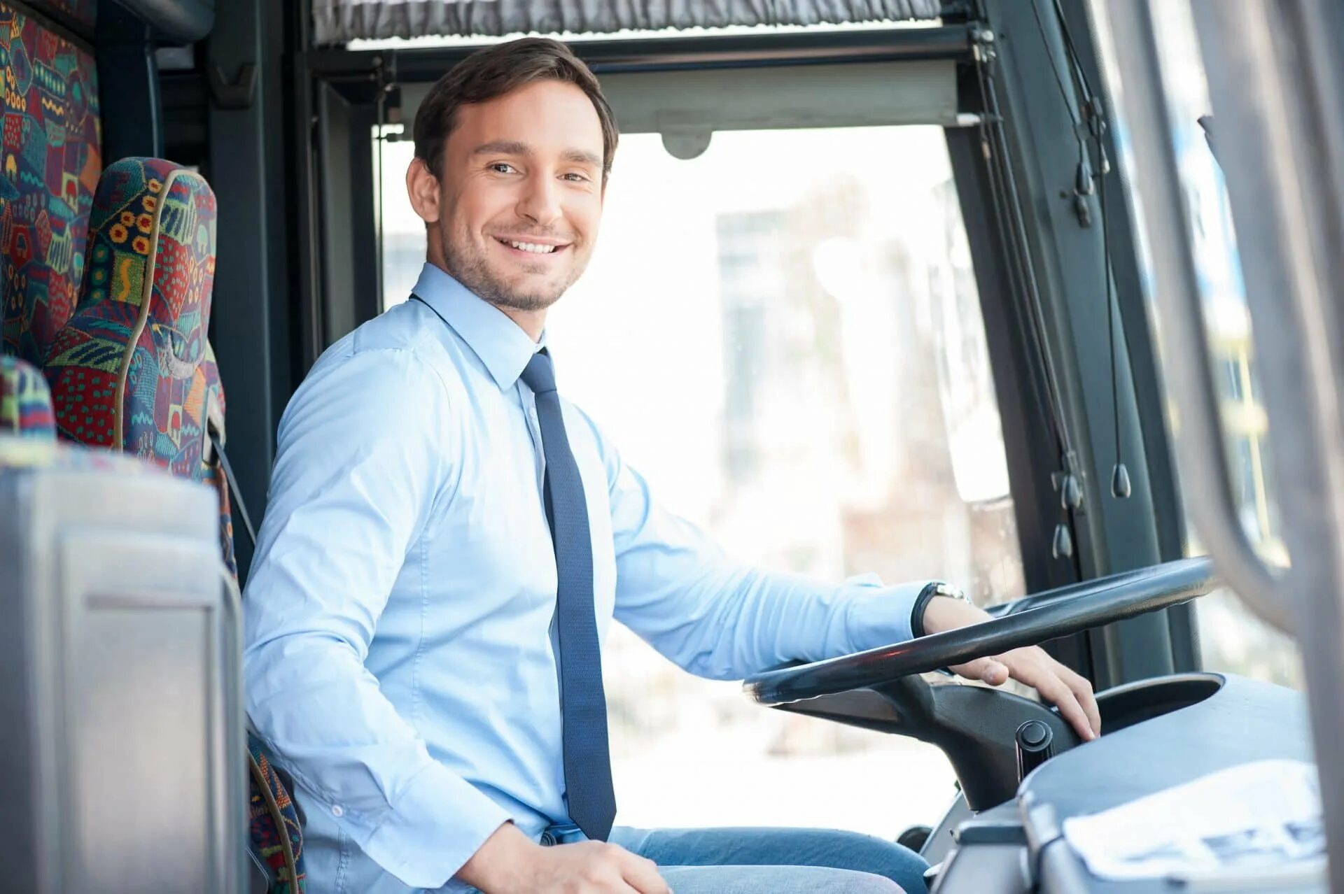 Водитель автобуса. Мужчина за рулем автобуса. Водитель автобуса улыбается. Шофер автобуса.