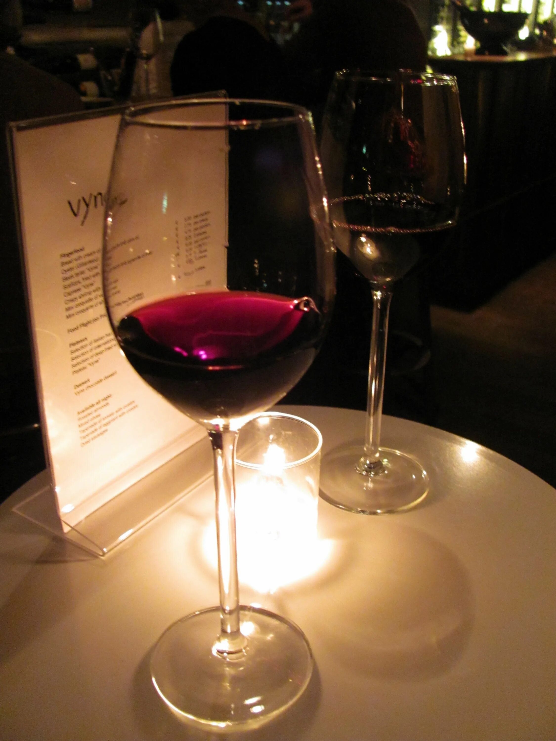 Бокал вина в ресторане. Бокал вина на столе в ресторане. Бокал с вином. Бокалы в ресторане.