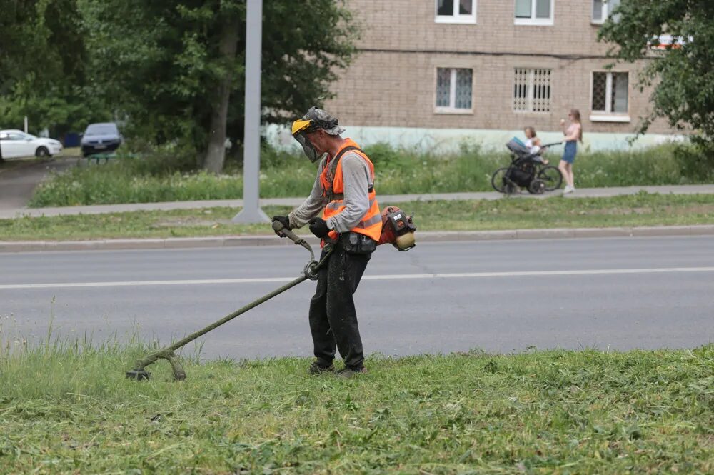 Косить траву. Скашивание травы вдоль трасс. Косят траву в городе. Осенью косят траву. Покос травы на обочинах автомобильных дорог.