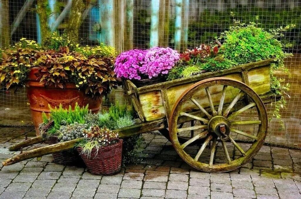 Цветочная барахолка старая. Клумба телега с цветами. Телега для декора сада. Старая телега с цветами. Телега для цветов.