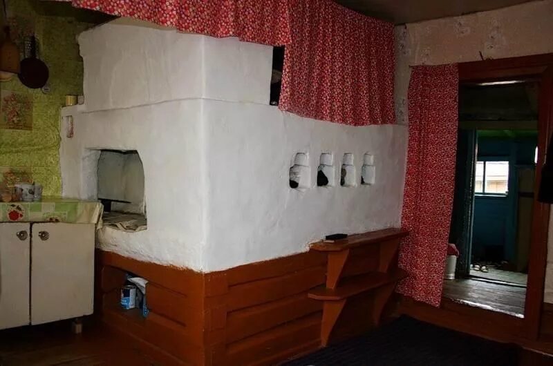 The original, old school Russian stove with a sleeping loft on top. Small cabin,
