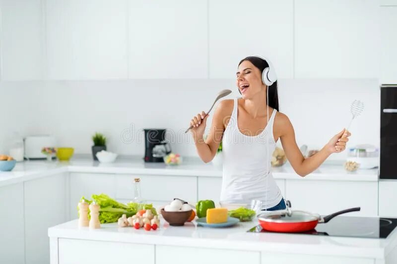 Singing cooks. Пение на кухне. Женщина поет на кухне. Женщина в наушниках на кухне. Девушка поет на кухне.