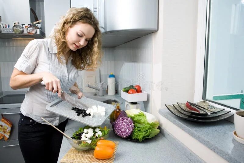 Сядь на кухне. Девушка готовит. Девушка готовит салат. Приготовление пищи на кухне. Женщина готовит на кухне.
