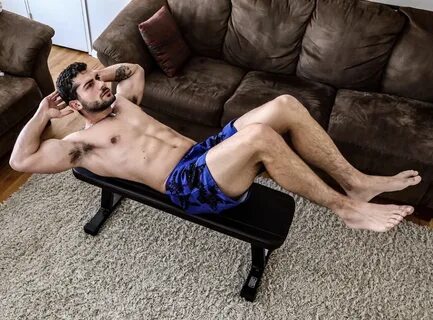 Bruno Baba doing sit-ups shirtless and barefoot.