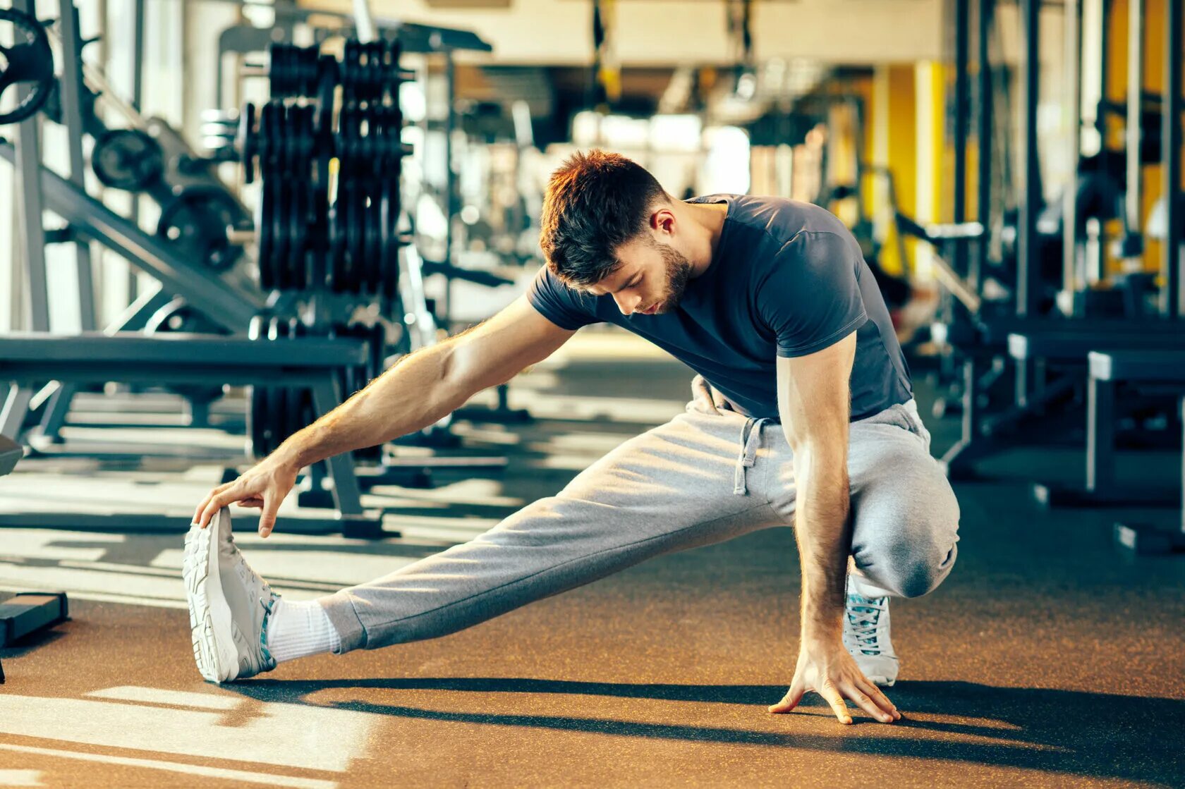 Physical taking. Разминка в спортзале. Тренировка в зале стретчинг. Растяжка в спортзале. Мужчина спорт.