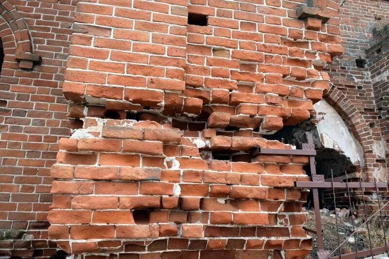 Разрушение стены здания. Вычинка кирпичной кладки. разрушение кирпичной кладки. разрушенное кирпичное здание. разрушенная кирпичная стена.