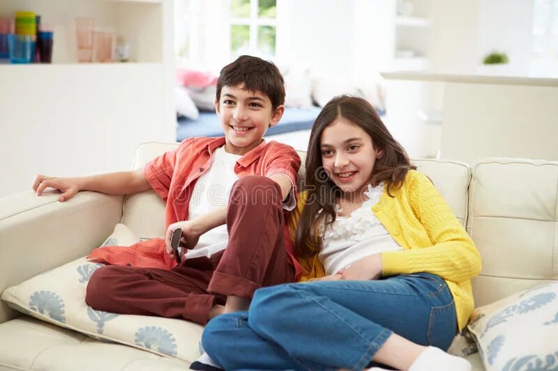 My brother watches tv. Kid sitting on luxurious Sofa. Family sitting on Sofa.