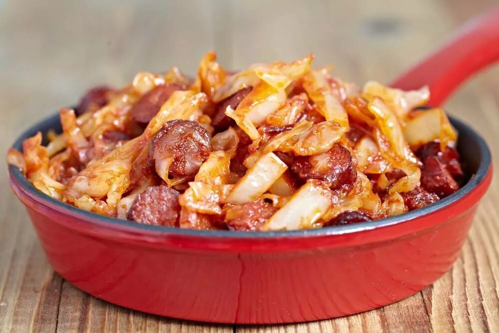 Солянка из капусты с мясом на сковороде. Капуста тушеная с колбасками. тушёная капуста с колбасой. солянка на сковороде. капуста тушёная с охотничьими колбасками.