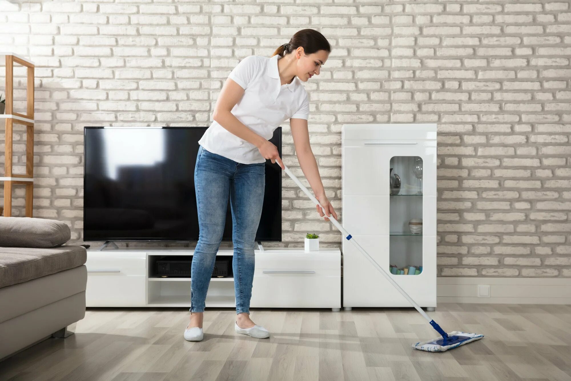 Floors are life. Floor with Mop in Living Room. Professional Wooden Floor Cleaning. The Floor of the clean Room. Cleaning the Living Room.