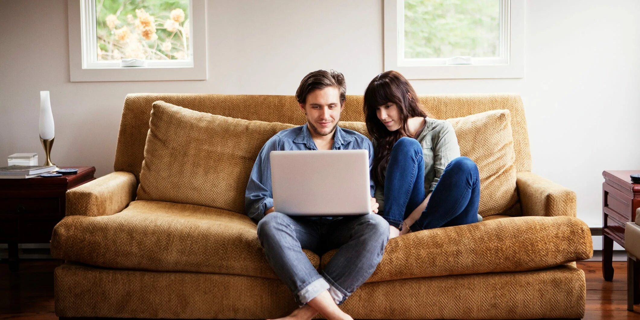 Человек отдыхает на диване в светлой гостиной. Man sitting in Living Room. Living Room with people. Man in the Living Room. People first lived in