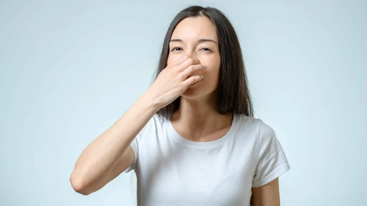 Девушка прикрывает нос. Девочка закрытым носом. Женщина закрывает нос. Плохой запах. Девочка закрытым носом.