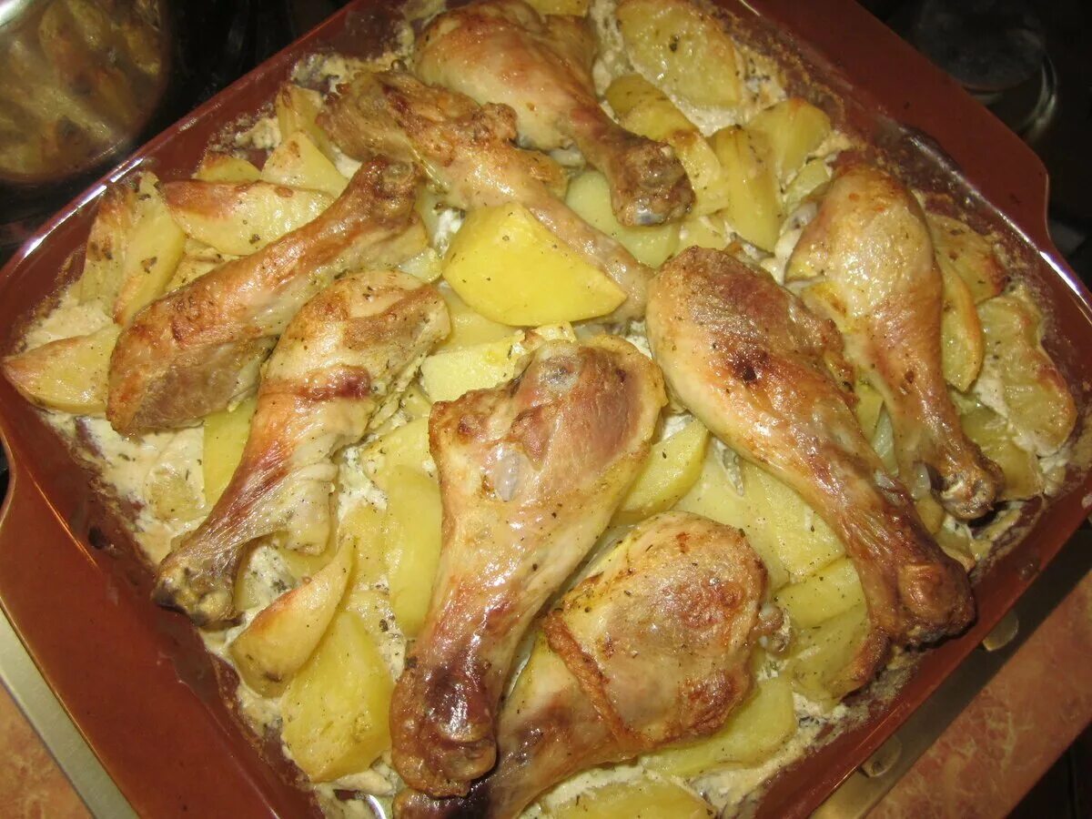Запечь бедра с картошкой. Курица с картошкой в духовке. голень с картошкой в духовке. картофель с курицей в духовке. картошка с куриными ножками.