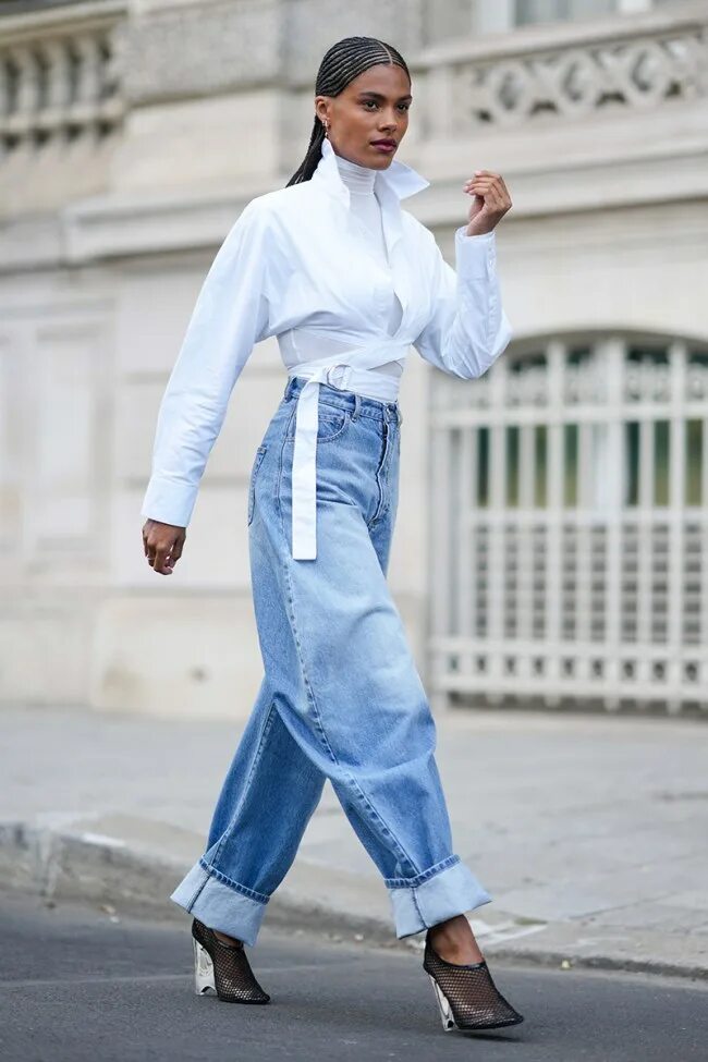 Самые модные джинсы 2024 женские. Юбка поверх джинс. Образы с белой рубашкой 2023. Белая рубашка с джинсами палаццо. Белые джинсы трубы.