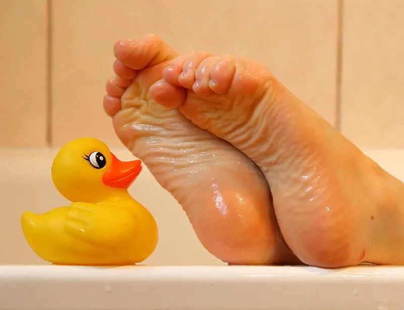 Желтые стопы. Ноги с уточкой в ванной. Женские пяточки в ванной. Женские ступни в ванной.