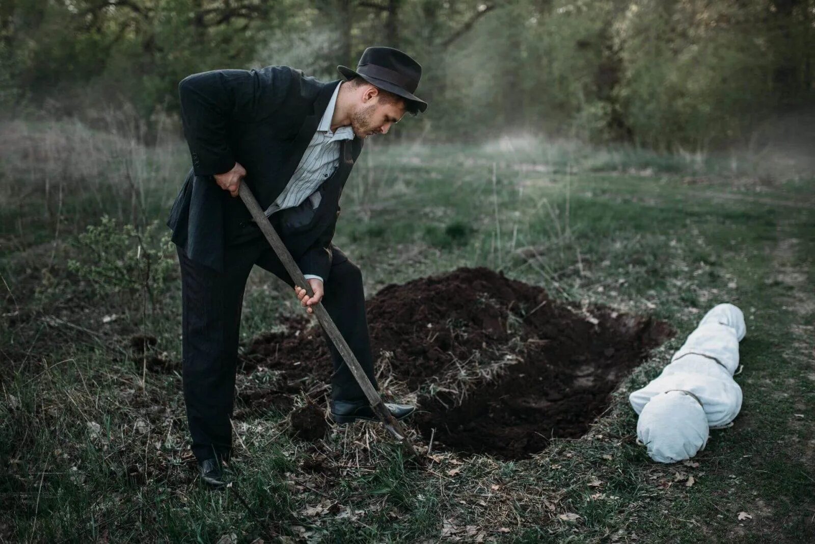Человек копает яму. Можно хоронить на своем участке