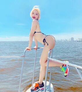 Standing in front of a series of bikini photos of DJ Soda - Korea’s No. 1 f...