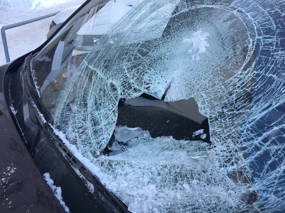 Разбитое лобовое стекло. Машина во льду. Треснутое лобовое. Снег на стекле машины.