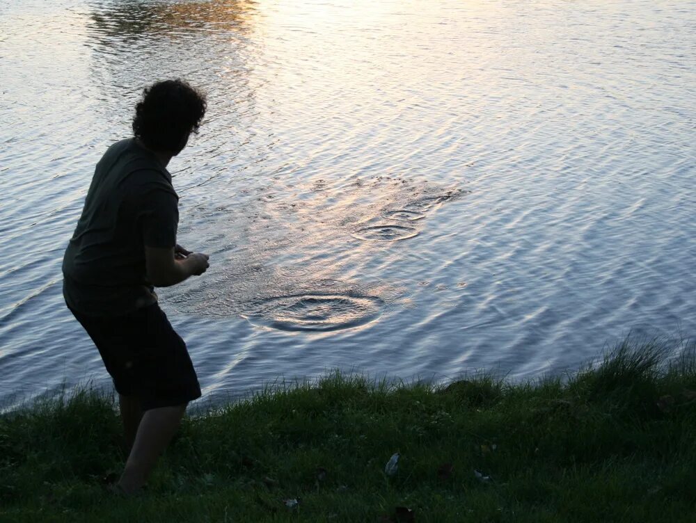 Блинчики по воде. Камень брошенный в воду. Камень брошенный в море. Бросает камень в реку.