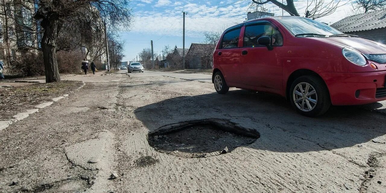 Колесо попало в яму на дороге. Яма для автомобиля. Автомобиль попал в яму на дороге. Колесо в яме.