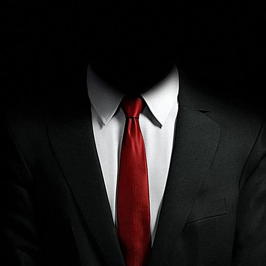 Угрожающий образ. Черный пиджак красный галстук. Костюм на черном фоне. Смокинг без лица. Мужчина в костюме с красным галстуком.