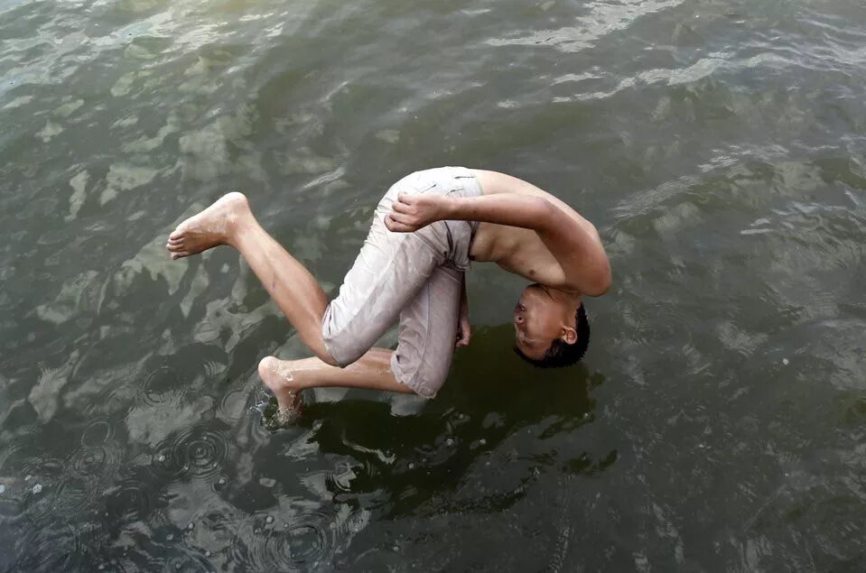 В воде ныряет в реку. Мужчина в воде. Парень ныряет. Вода и человек.