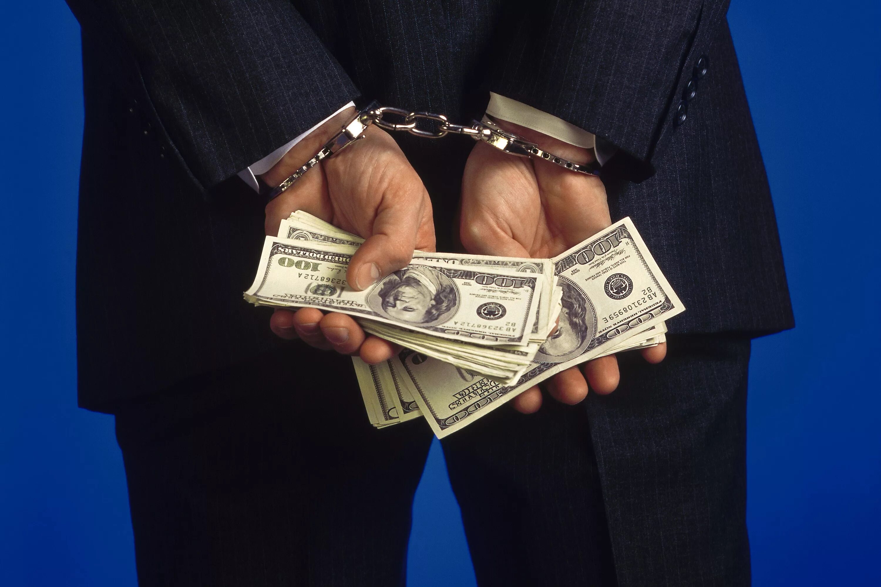 Мошенничество отмывание денег. Руки в наручниках с деньгами. Коррупция. Коррупционная преступность.
