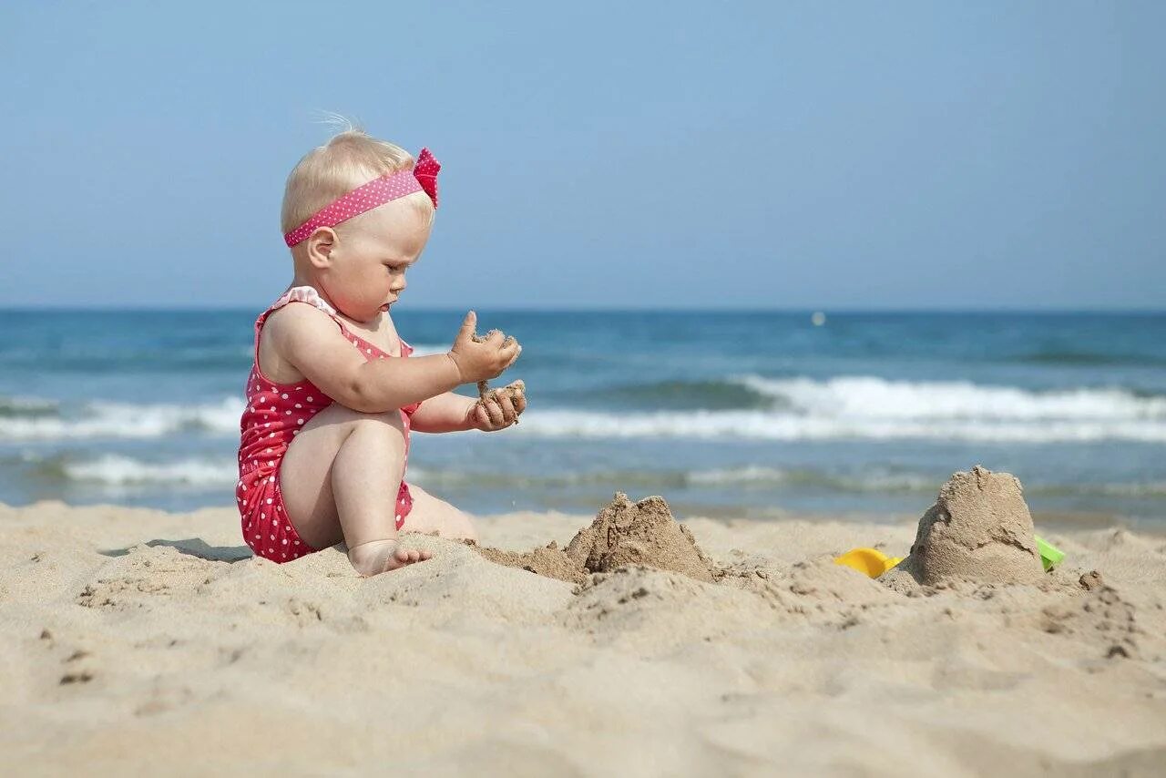 Море песок ребенок. Ребенок в пледе. Дети на море. Малыш на пляже. Маленькие дети на море.