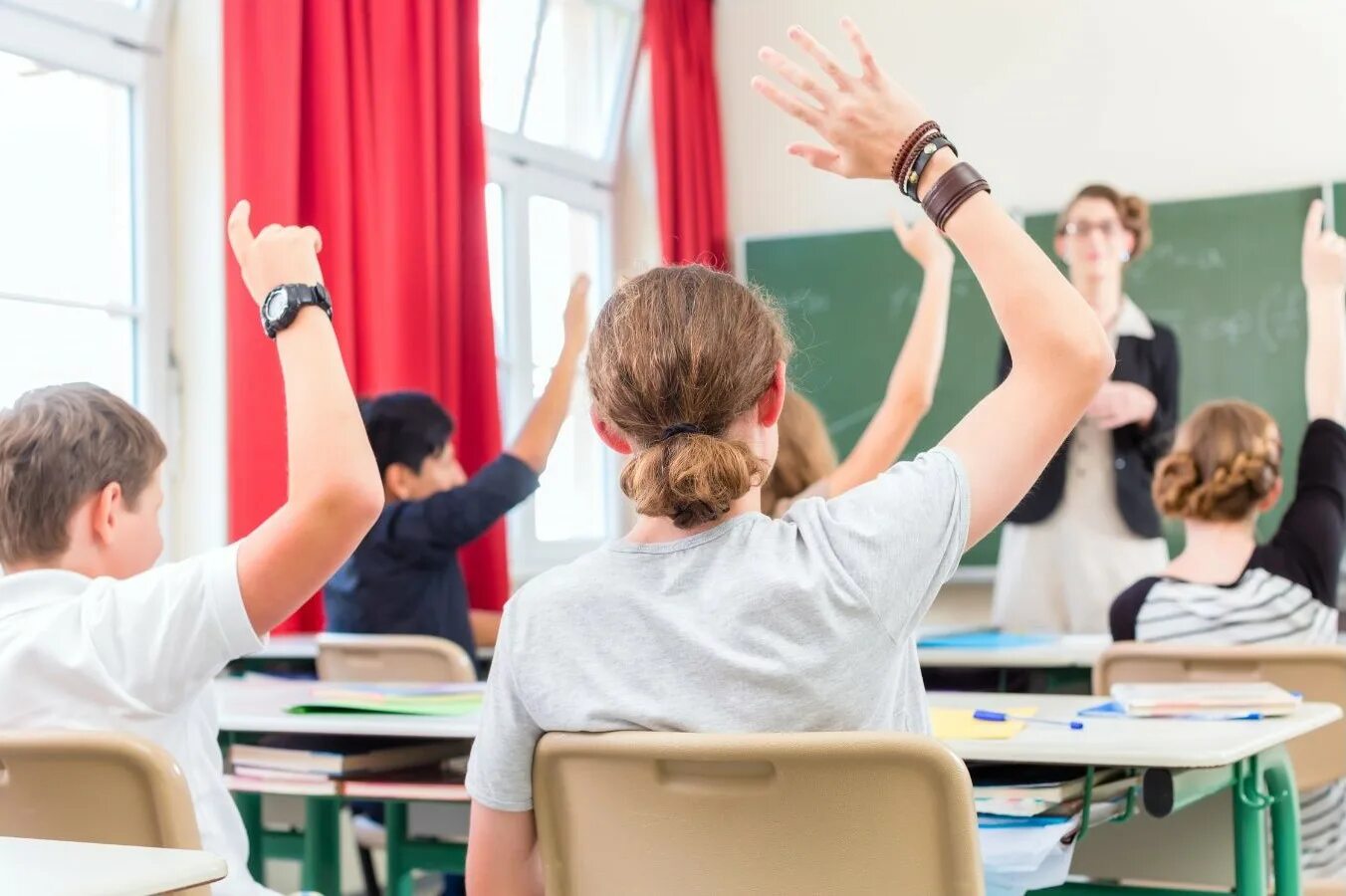 The teacher made the pupils. Фотография класса с учащимися с поднятыми руками. Школьный класс в Австрии. Студент поднимает руку. Младшие школьники поднимают руки.