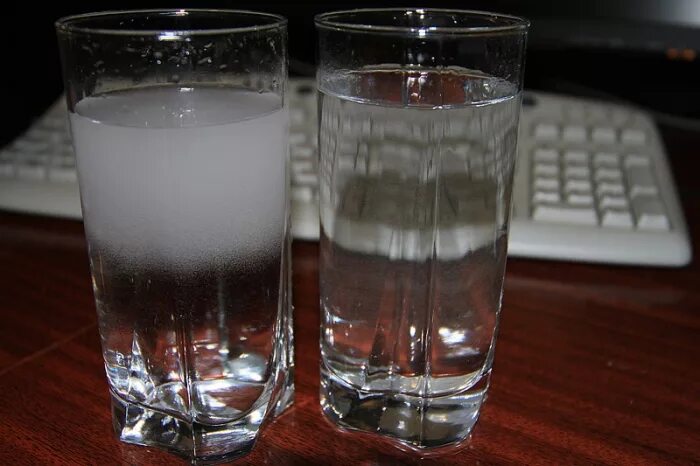Налейте в пластиковый стакан воды. Стакан воды. Холодный стакан. Разлитый стакан. Талая вода в стакане.