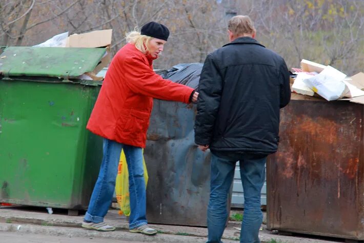 Женщина роется в мусорке. Немцы роются в помойках.