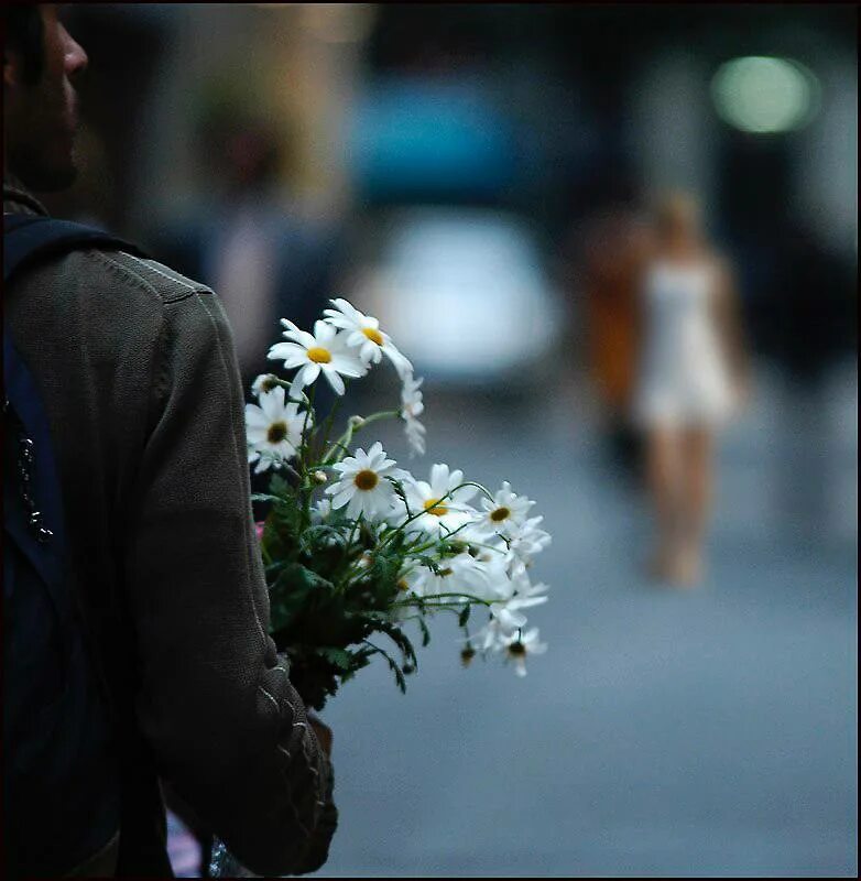 Мужчина с цветами со спины. Я несу тебе навстречу и несу. Я несу тебе навстречу и несу. Мужчина дарит цветы. Несу тебе цветы.