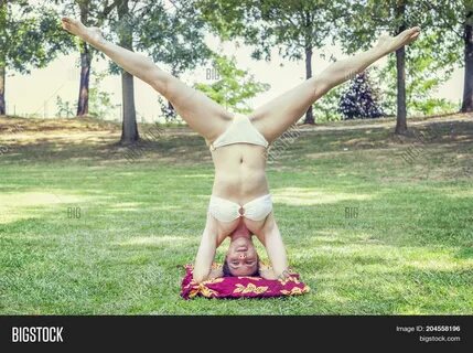 Download high-quality young woman does handstands public park images