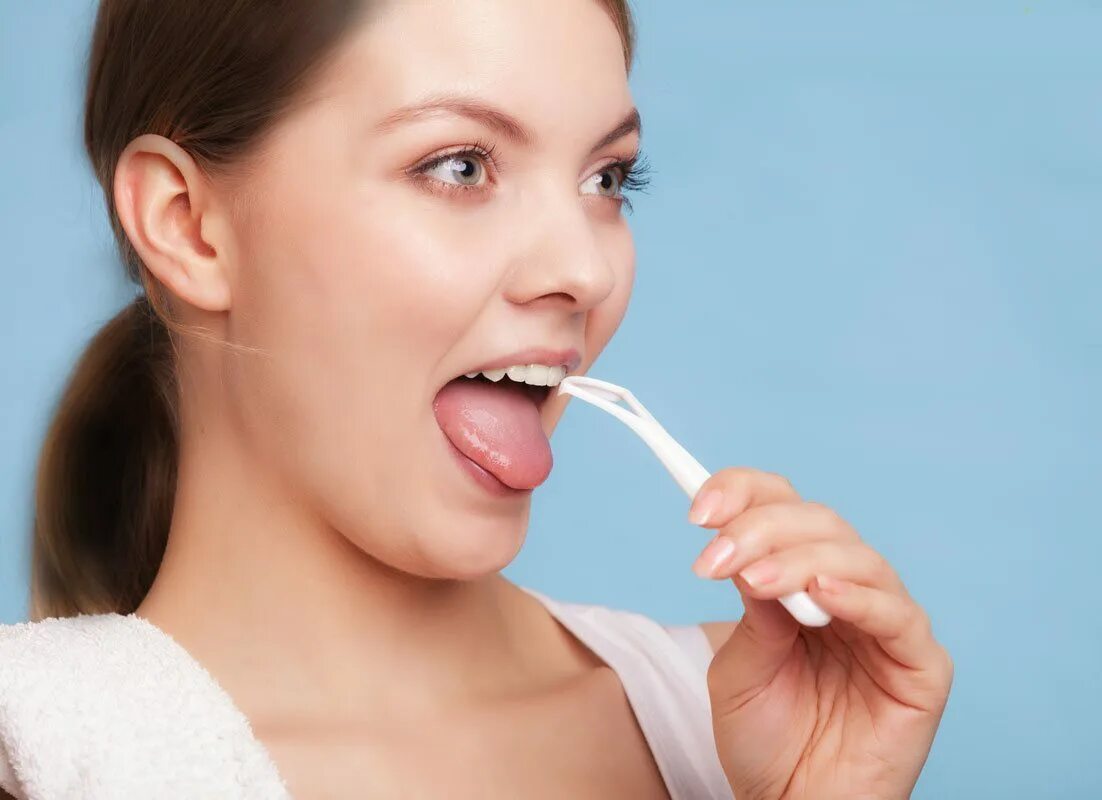 После чистки языка. Девушка чистит зубы.