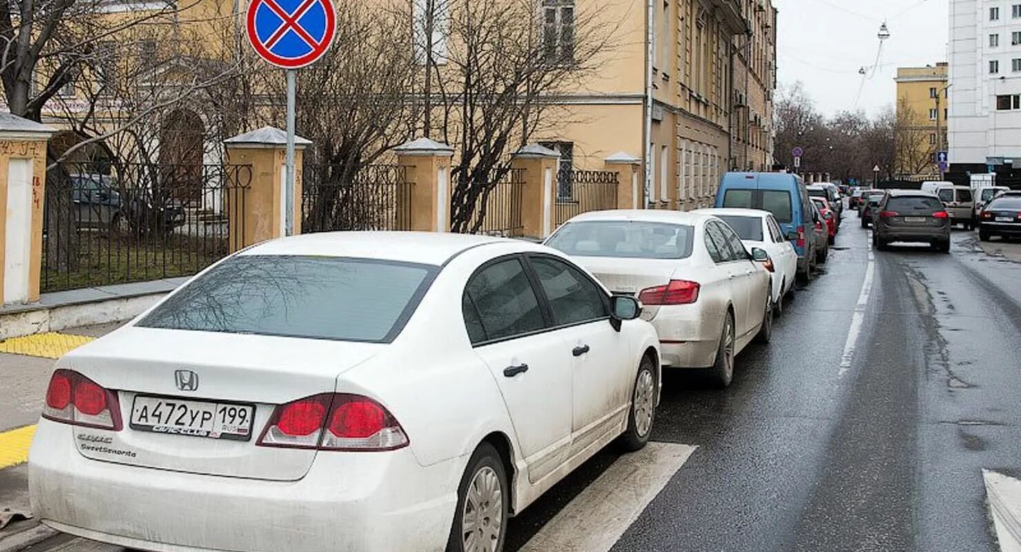 Стоянка в неположенном месте. Нарушение правил парковки. Парковка автомобиля в неположенном месте. Припаркованные машины вдоль дороги.