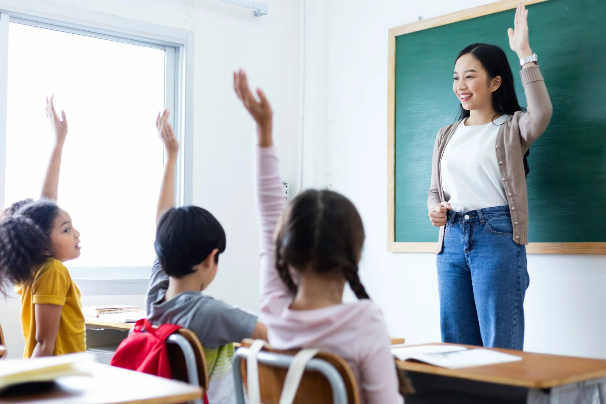 The teacher all the questions. Children in the Classroom. Girls Classroom back view.