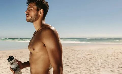 Man on beach with muscular chest not moobs or man boobs.