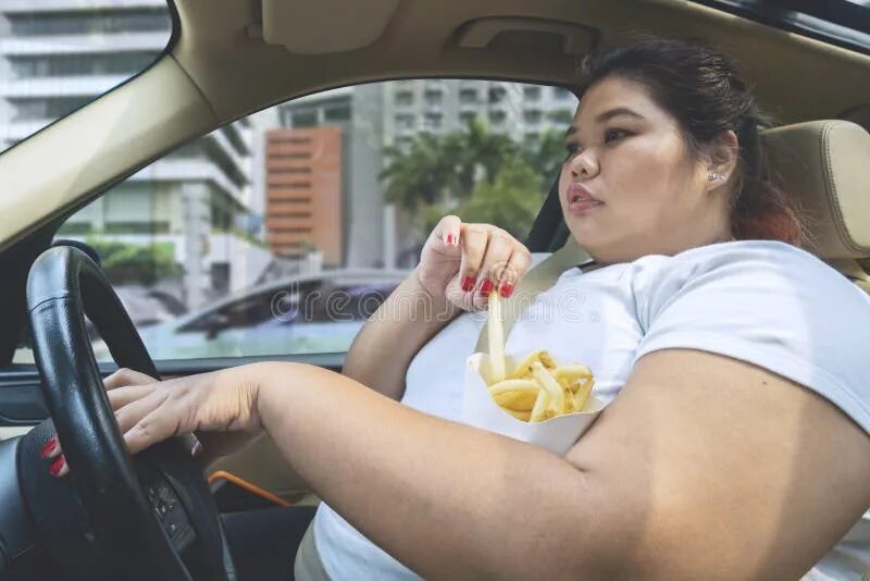 During driving. Asian woman eats on vacation.