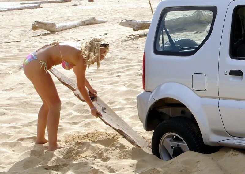 Женщина застряла в машинке. Машина застряла в песке. Девушка застряла в песке. Застряли в песке на пляже. Машина застряла на пляже.