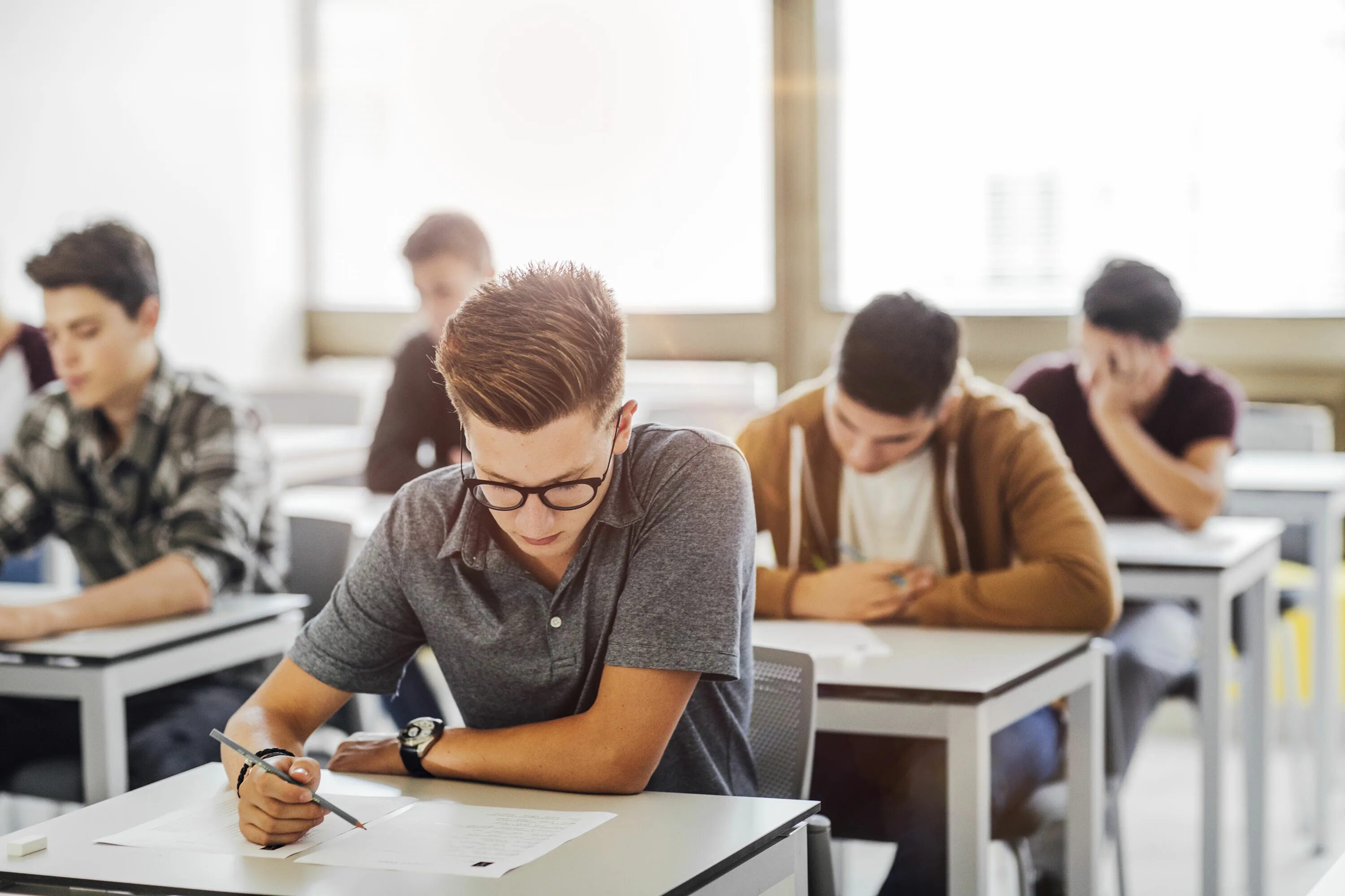 Student papers. Экзамен в вузе. Студент контрольная. Студент на экзамене. Студент за партой.