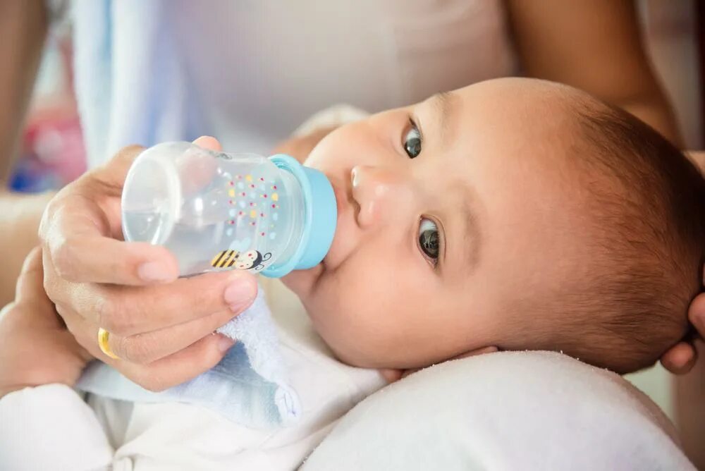 Дети пьют из бутылки. Малыш с бутылочкой. Бутылочка для кормления. Вода для новорожденных при грудном вскармливании. Питье для новорожденного ребенка.