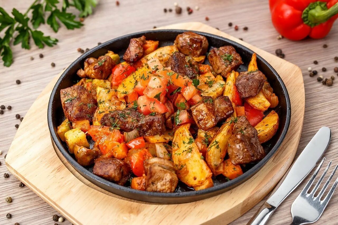 Блюдо с картошкой и овощами. Оджахури на сковороде. грузинское блюдо оджахури. жаркое из свинины с картошкой. мясо с овощами.
