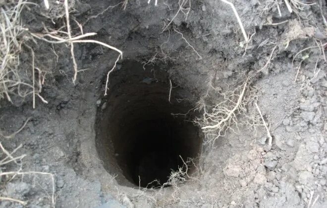 Лунки под столбы. Бурение лунок под столбы для забора. Бурение ям под столбы. Бетонирование столбов 100х100. Лунка под столб.