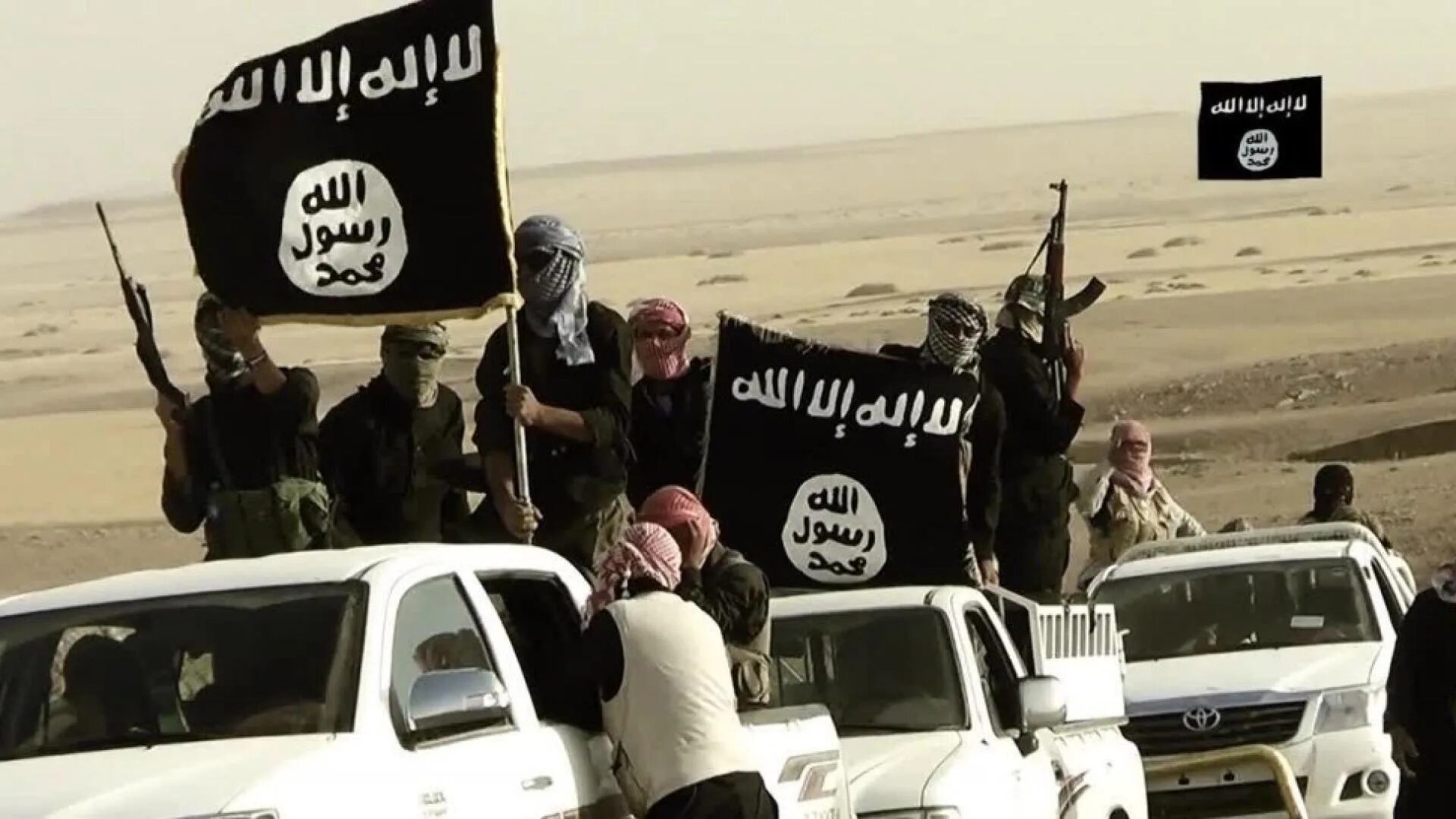 Террористы на фоне флага игил. Флаг ИГИЛ. Флаг террористов ИГИЛ. Флаг исламских террористов. Флаг Исламского государства.
