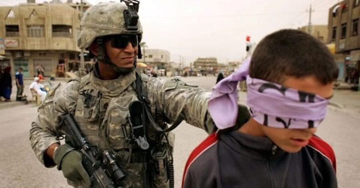 Все люди кроме нее стали жертвами вторжения. Американские солдаты и дети в Ираке.
