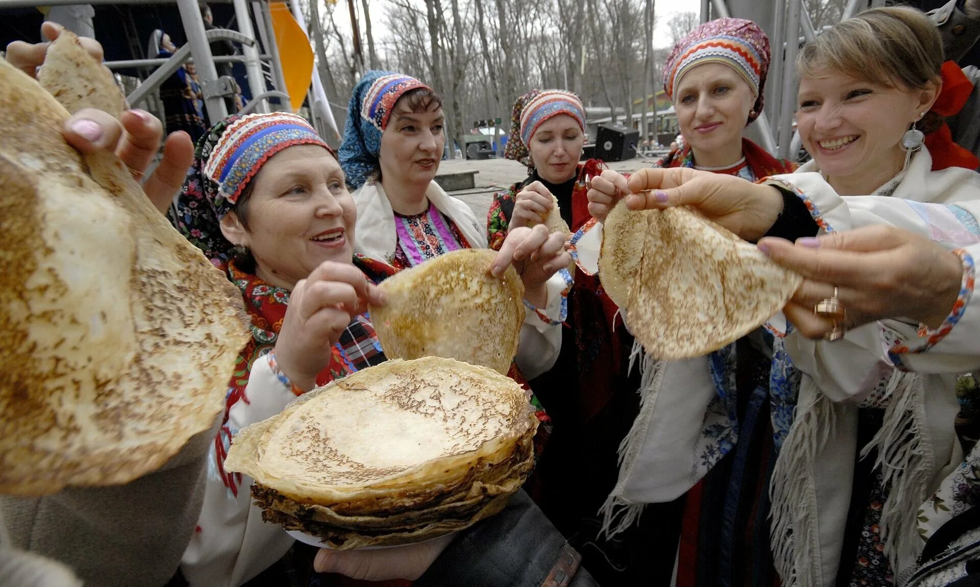 На масленице жирной водились русские блины. Масленичные угощения. Угощение блинами на Масленицу. Масленица пекут блины. Поедание блинов на Масленицу.