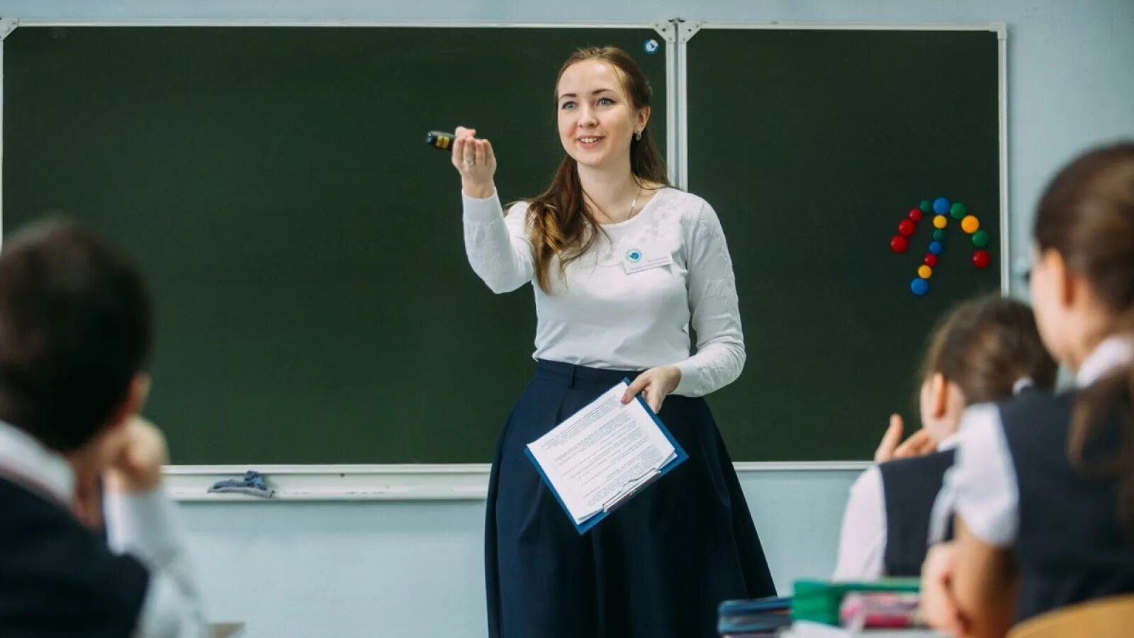 Стоит на учительницу