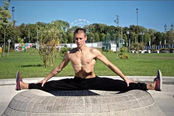 Человек на шпагате. Парень садится на шпагат. Продольный шпагат мужчины. Парень шпагат на пляже. Мужчина на шпагате.