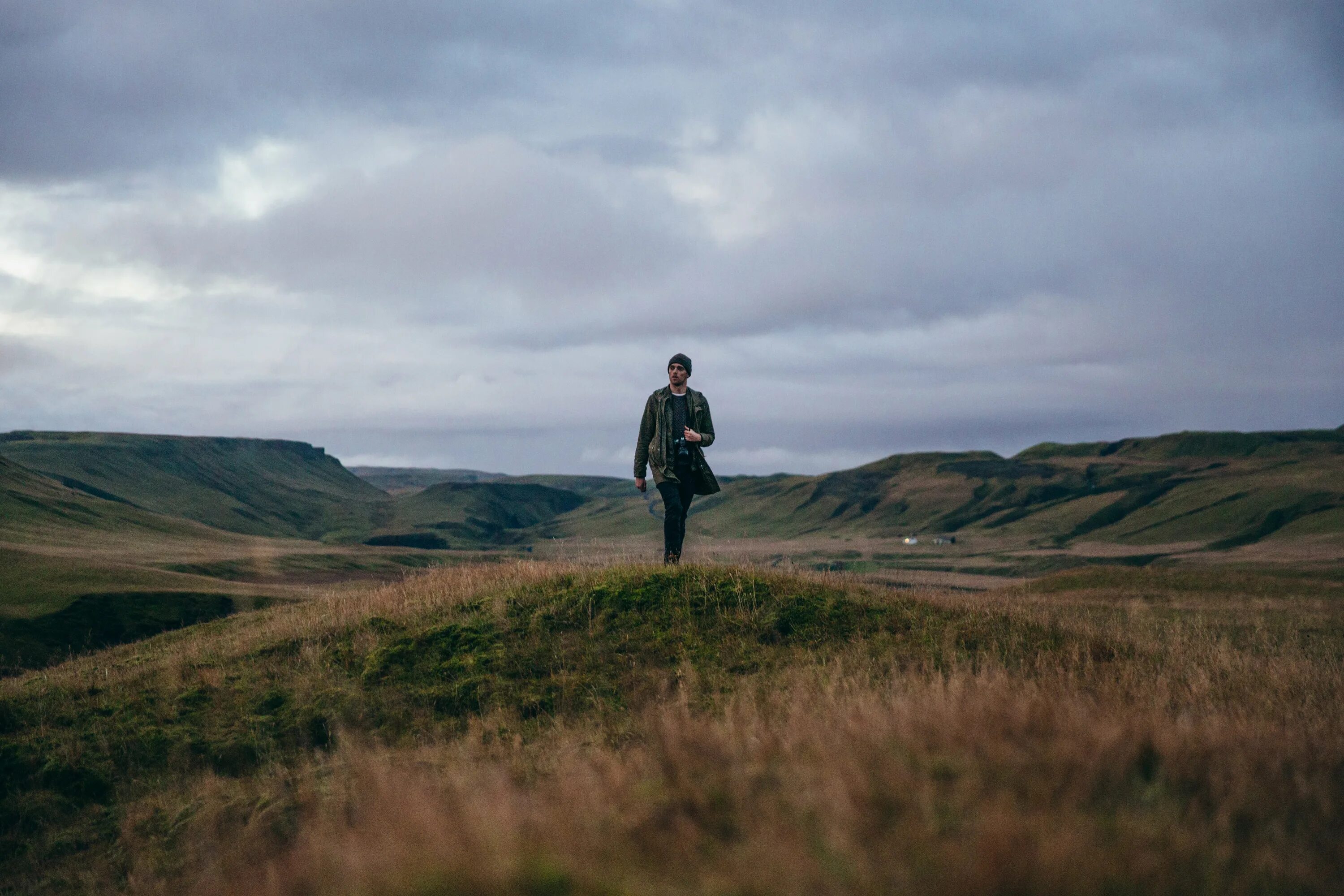 Великие холмы. Поле с скалистыми холмами. Исландия поля. Фото мужчина в степи делает фото.